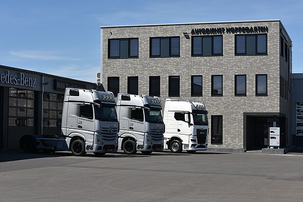 Lkw Flotte vor Unternehmensgebäude 