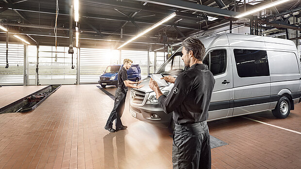 Mitarbeiter in der Werkstatt arbeiten an Transporter